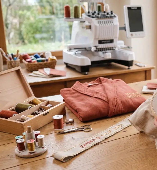 mains brodant un prénom sur un accessoire EVJF dans un atelier artisanal